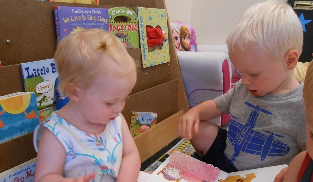 Two children looking at books in a classroom