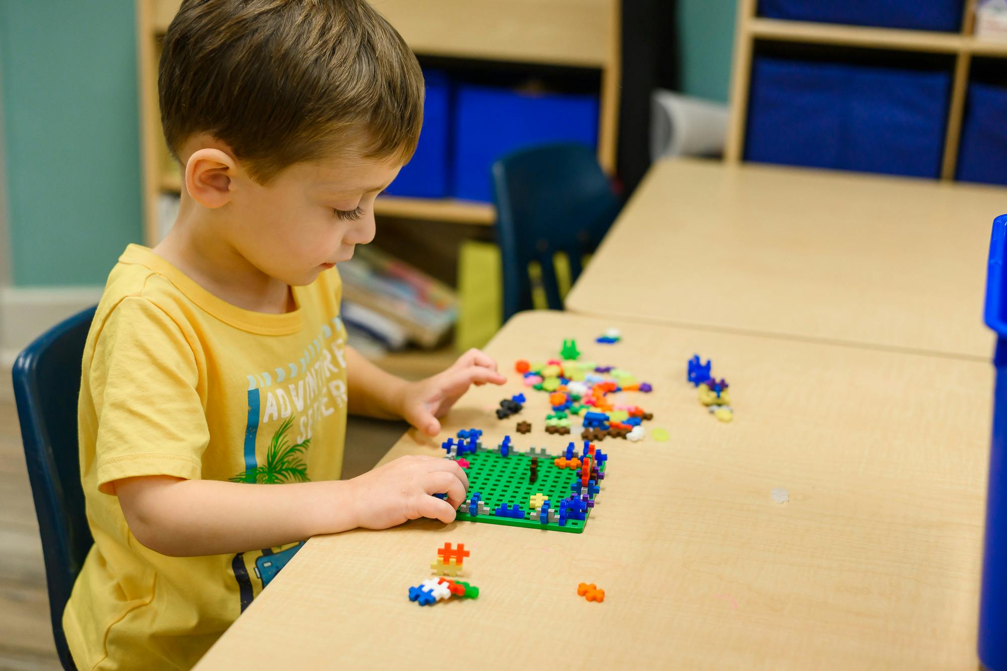 Child playing with colorful building blocks at a table