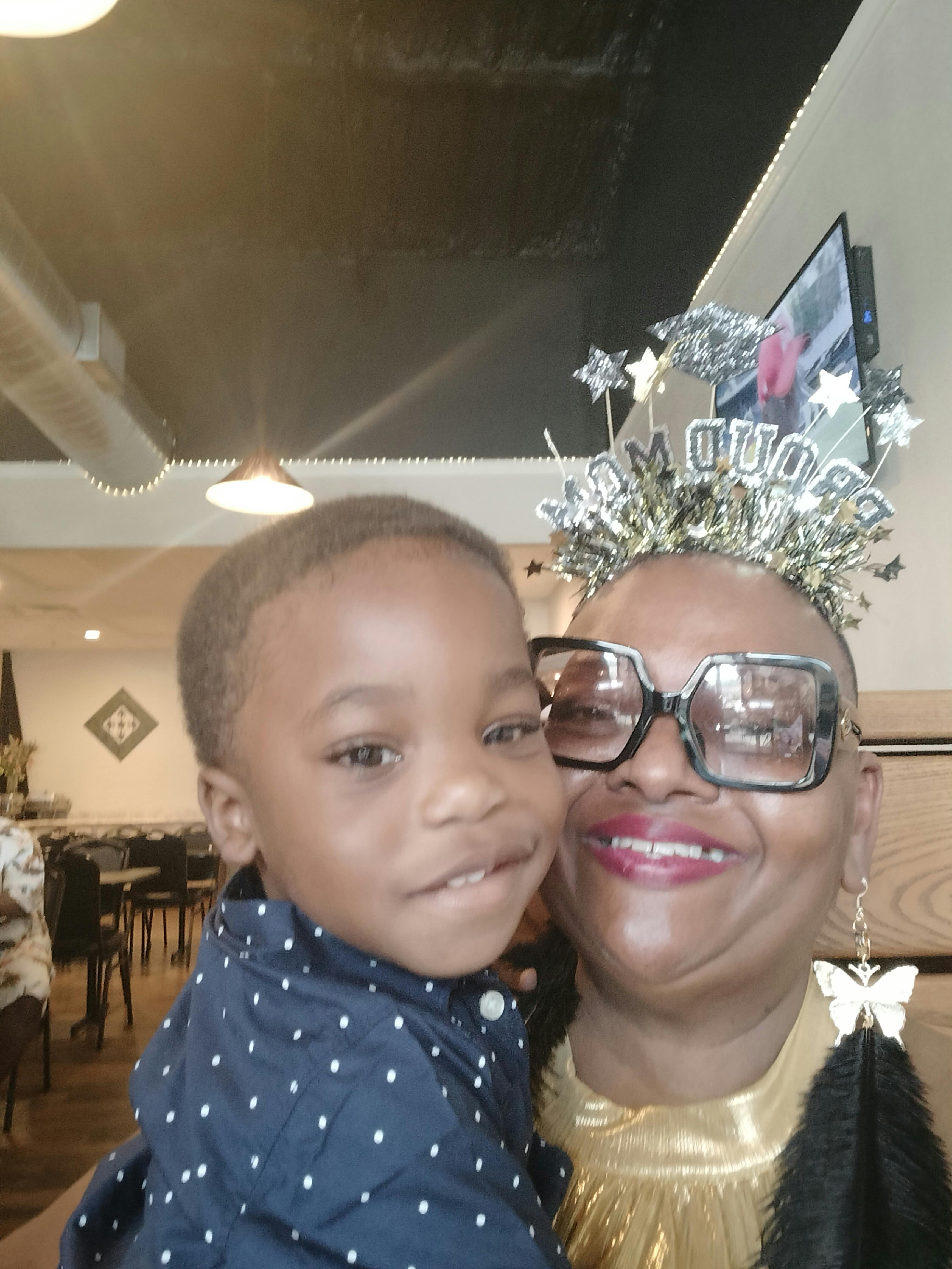 Person in glasses and party hat holding a child