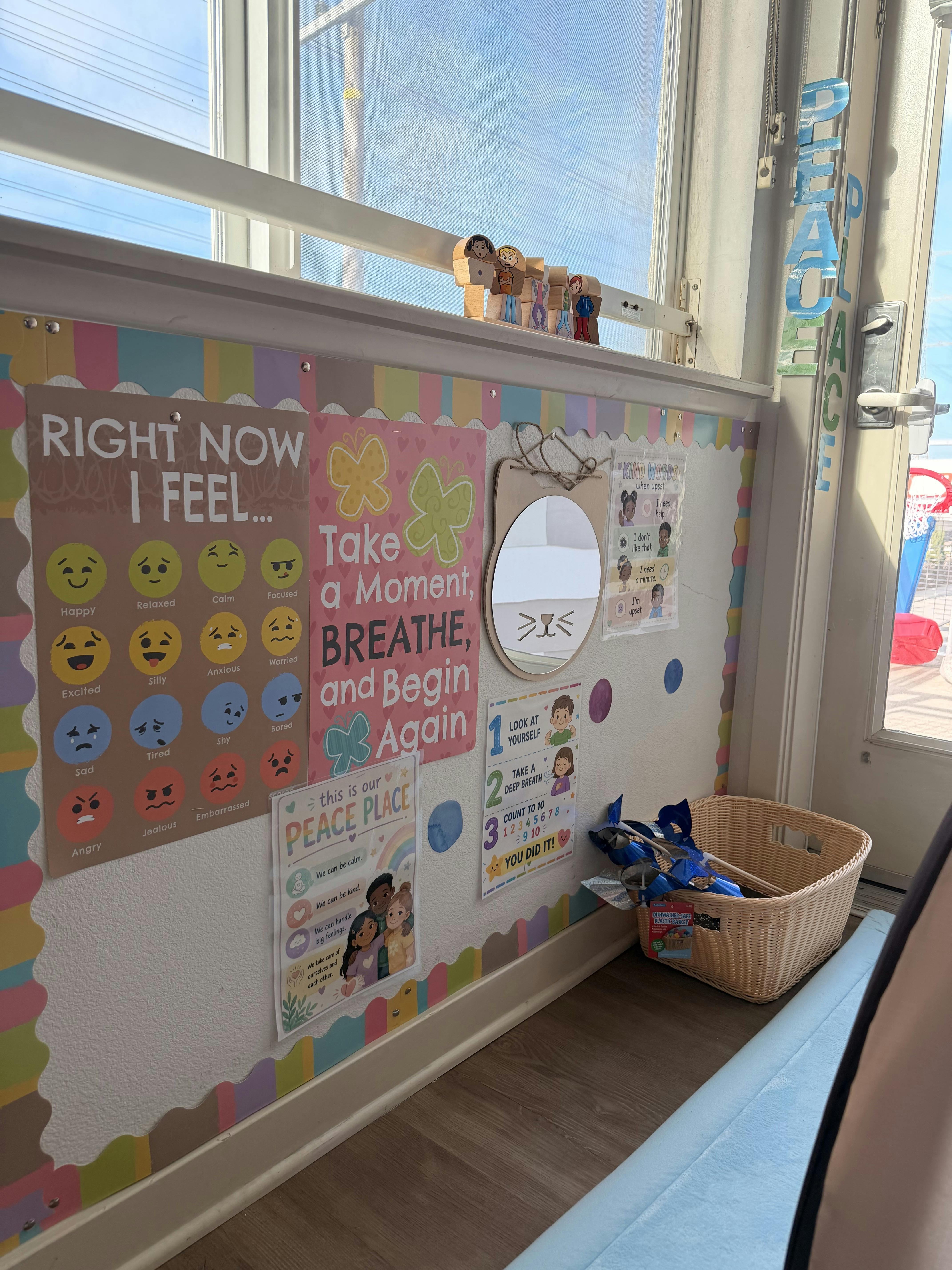 Classroom wall decorated with emotional regulation posters and a cat mirror