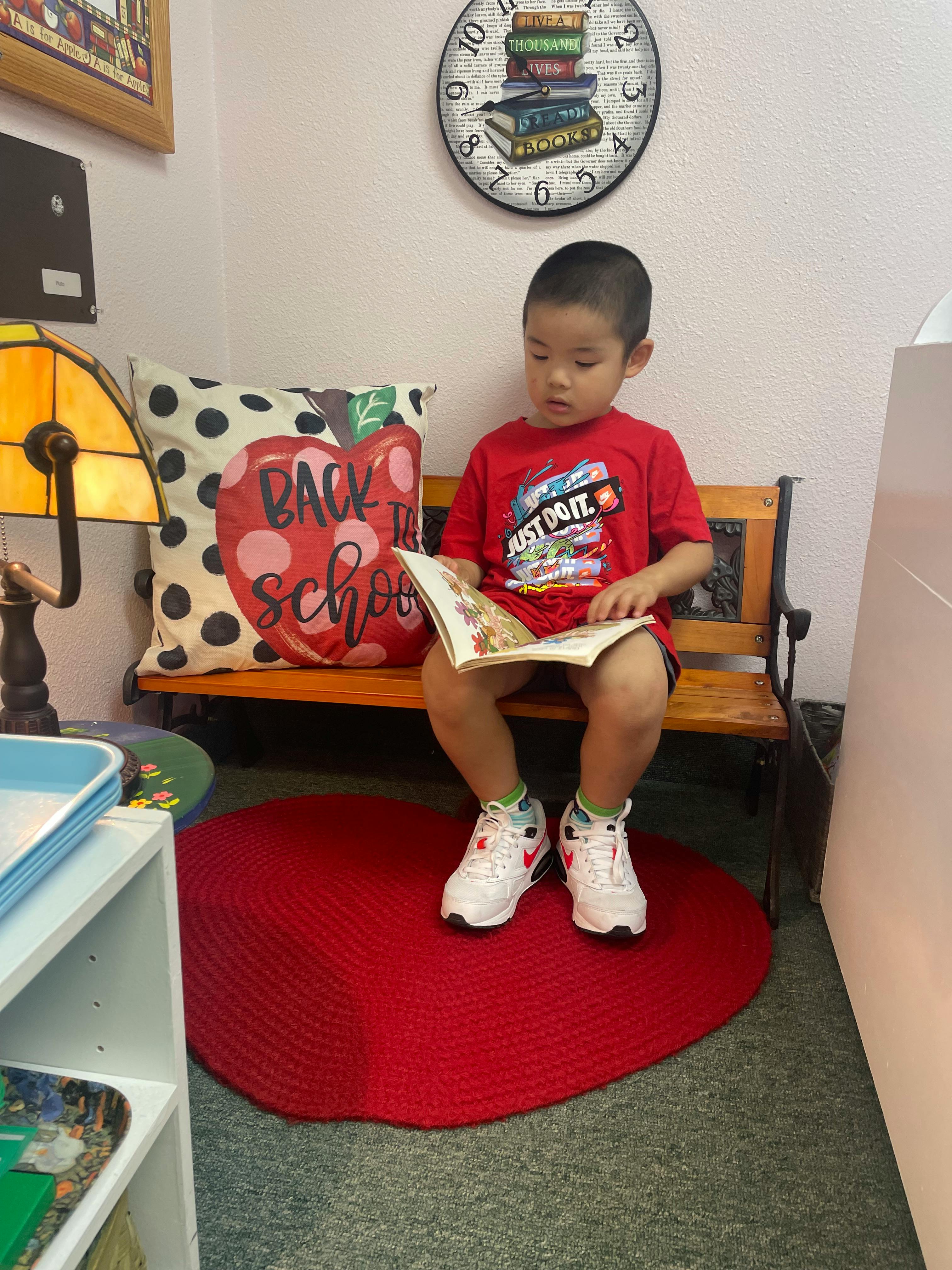 Child sitting on a bench reading a book