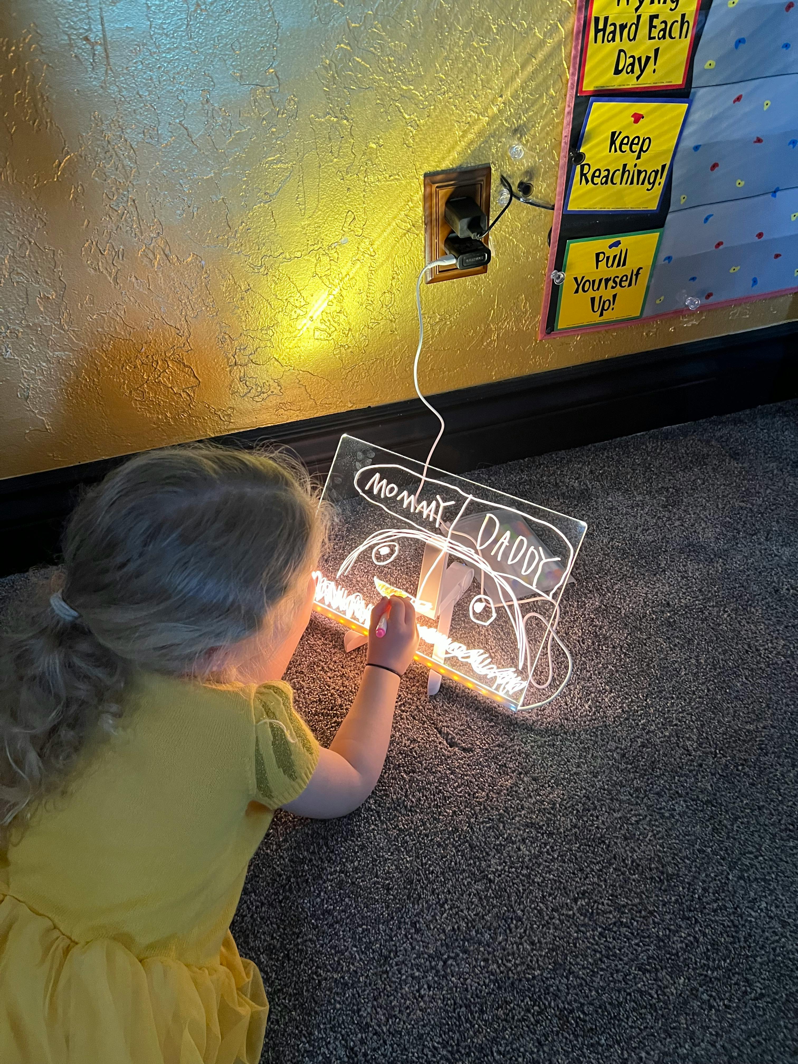 Child drawing on a light-up board on the floor