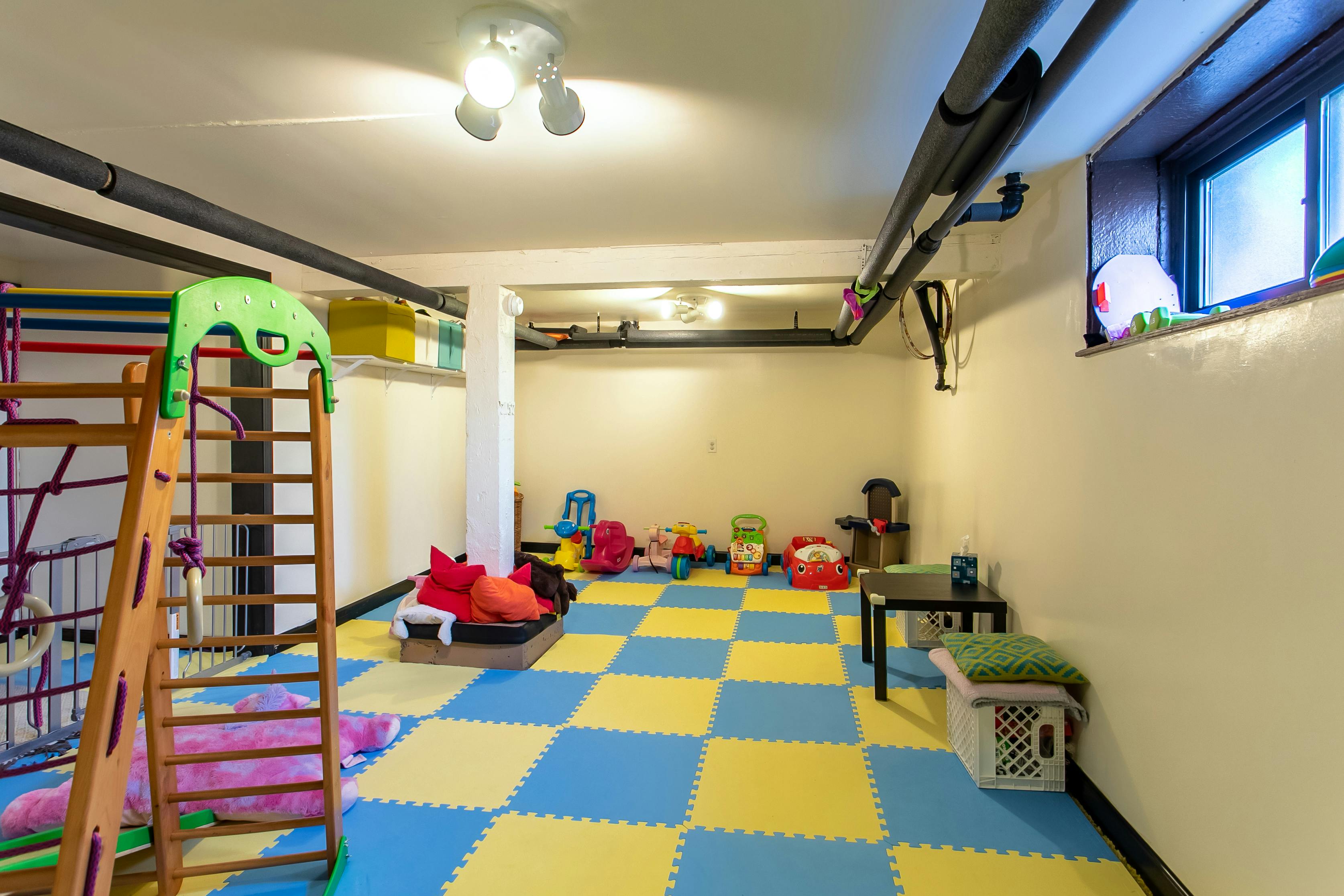 Playroom with blue and yellow checkered floor mats and play equipment