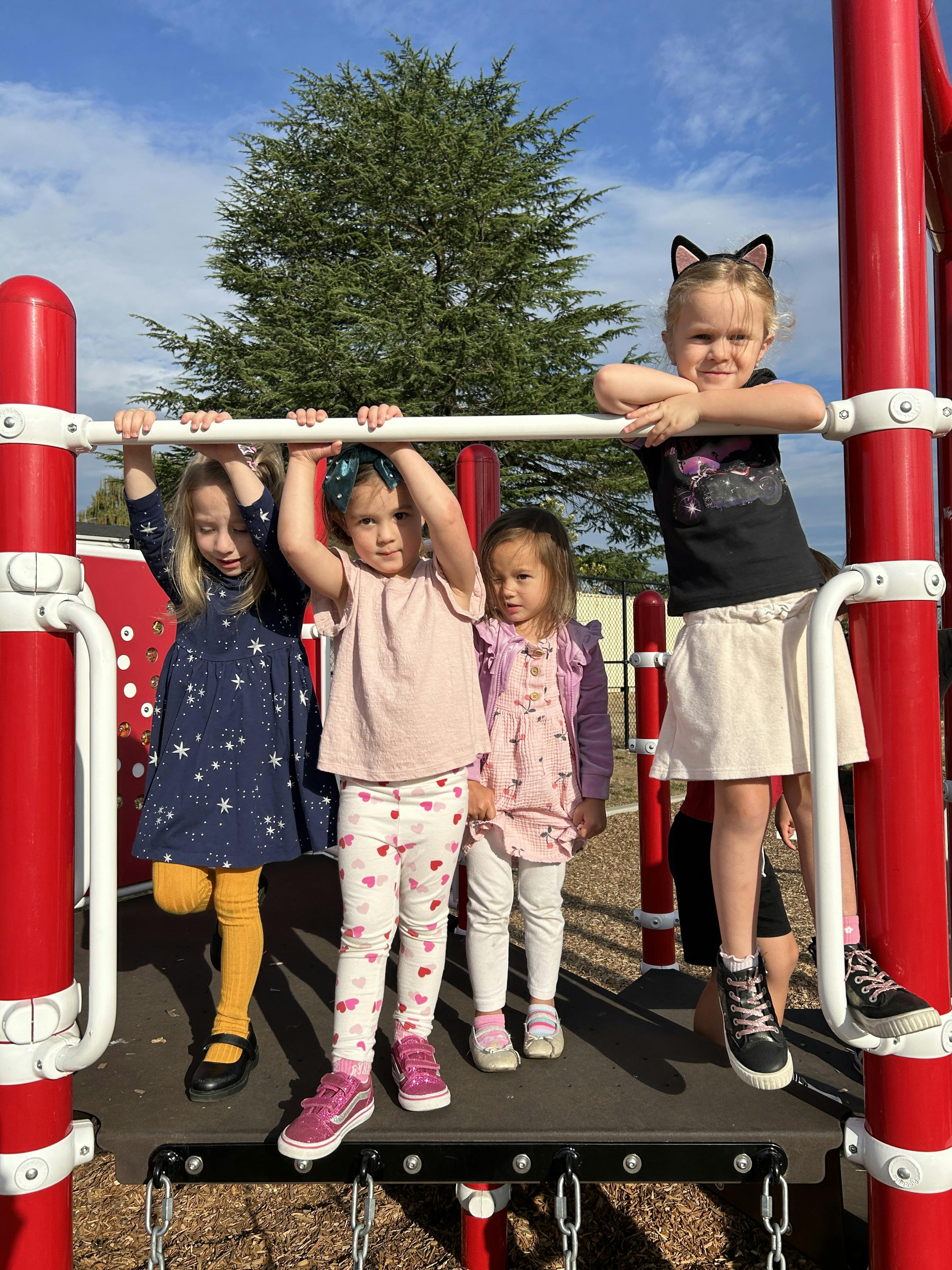 Four children on a playground structure