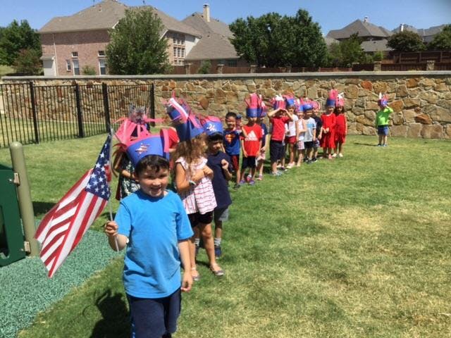 Children in a line holding small flags