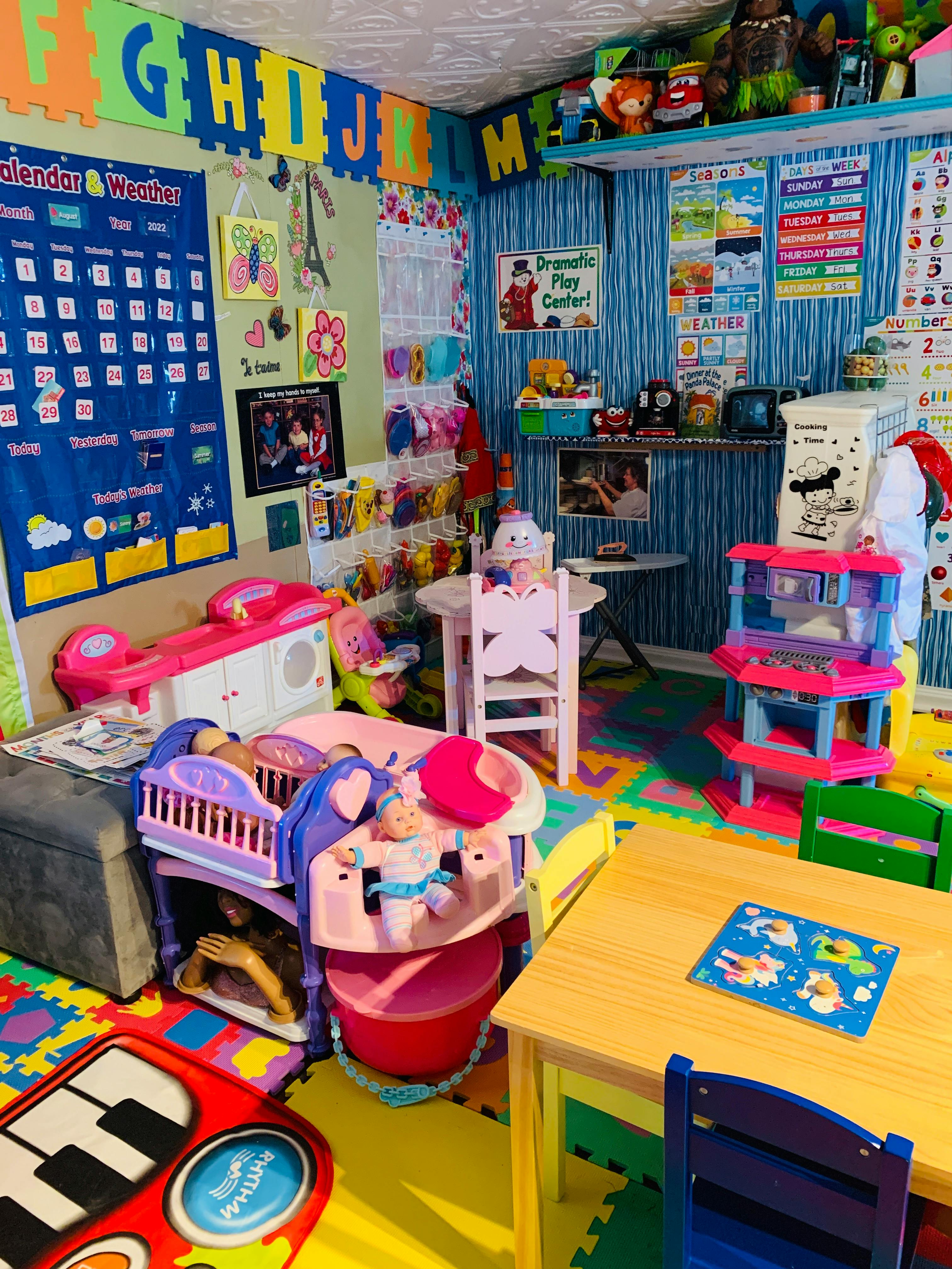 A colorful playroom with toys, a calendar, and alphabet letters on the wall