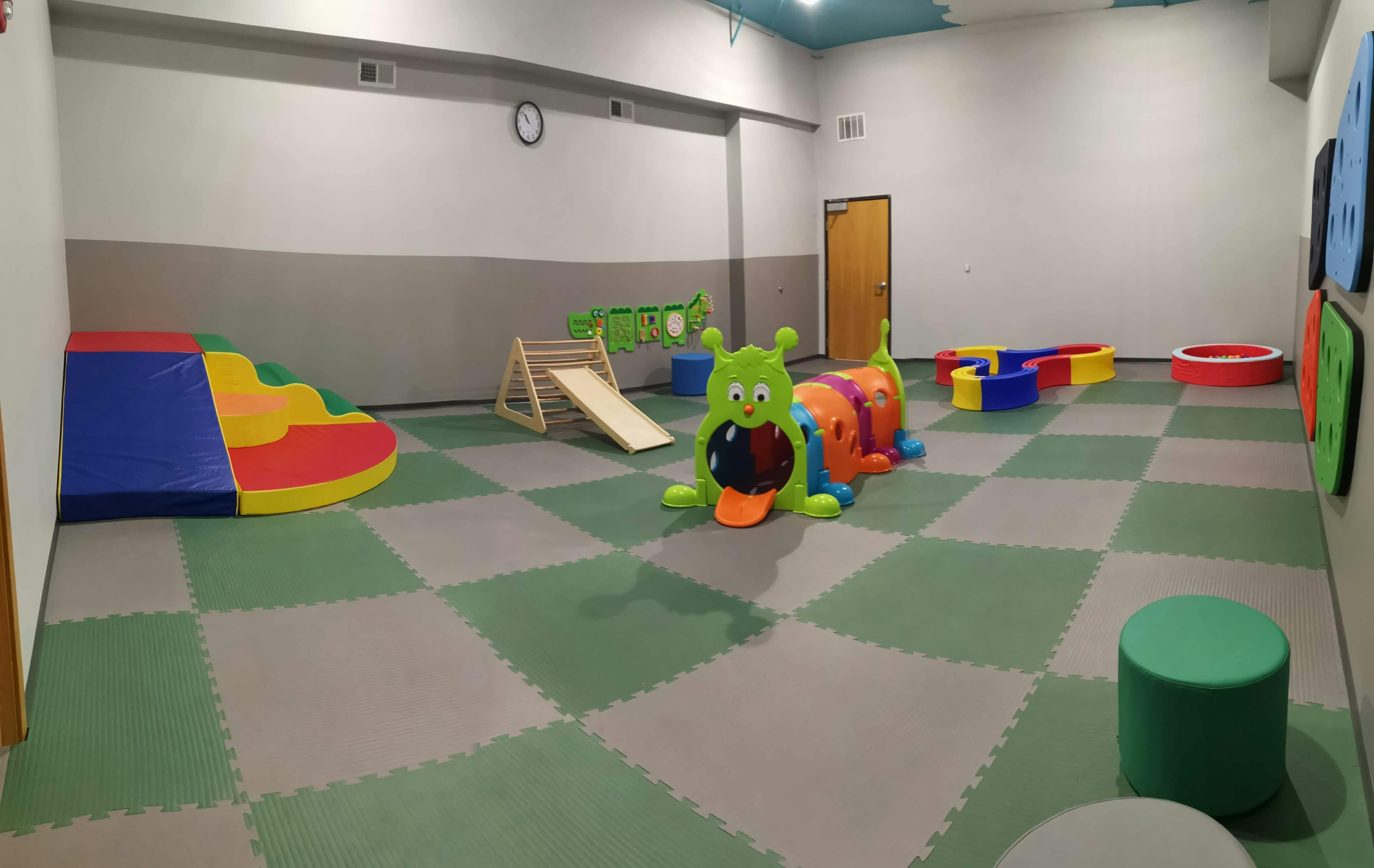 Indoor play area with soft play equipment and a caterpillar tunnel