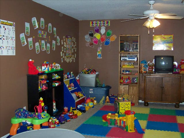 Playroom with toys, shelves, and colorful floor mats