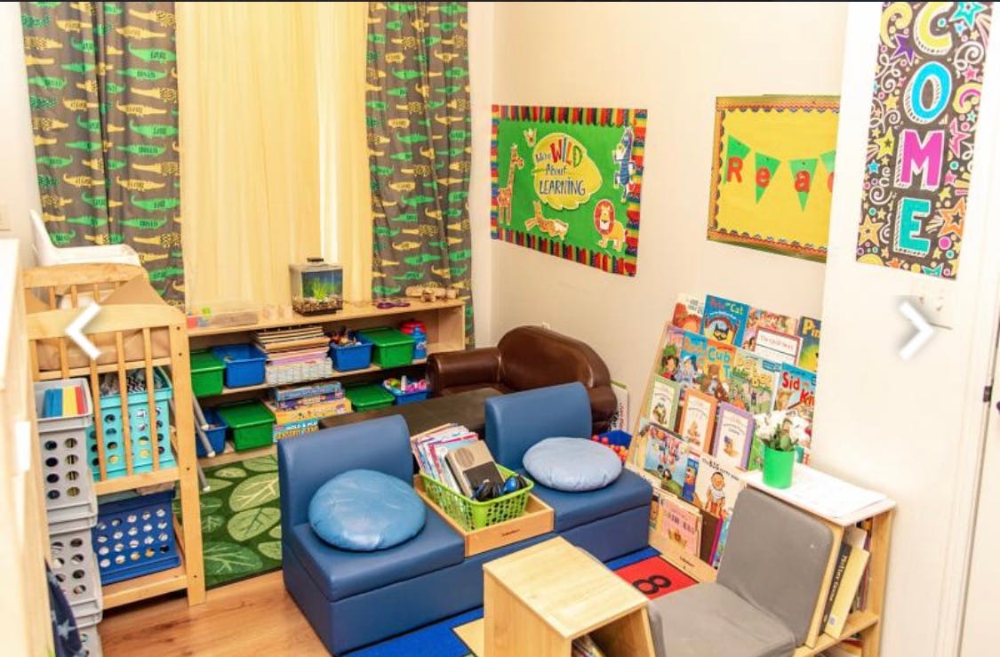 Classroom with blue chairs, bookshelves, and colorful wall decorations