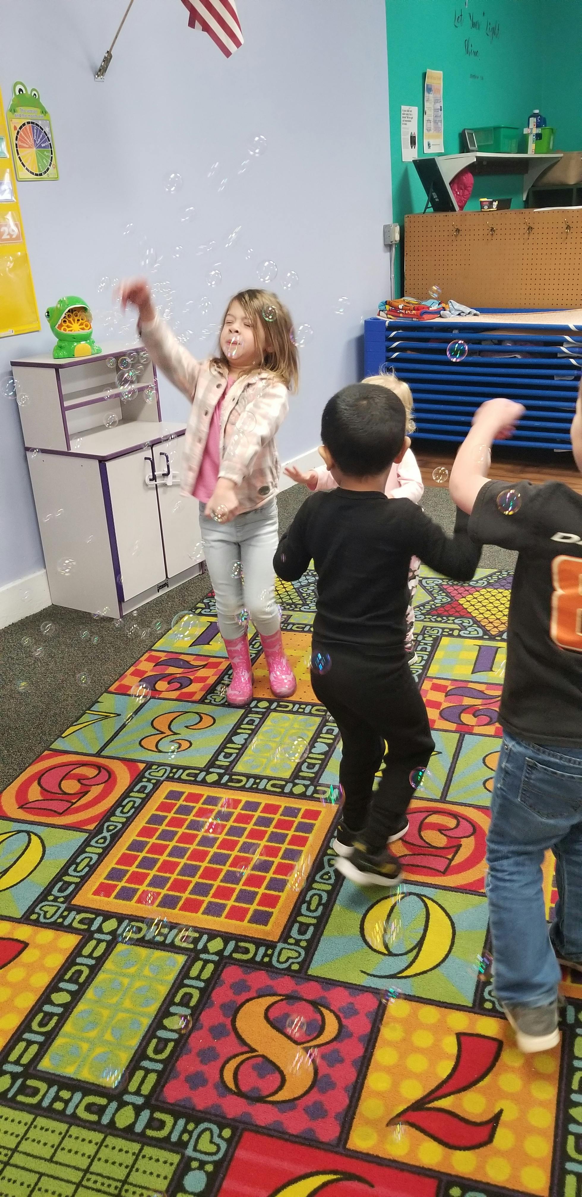 Children playing with bubbles in a classroom