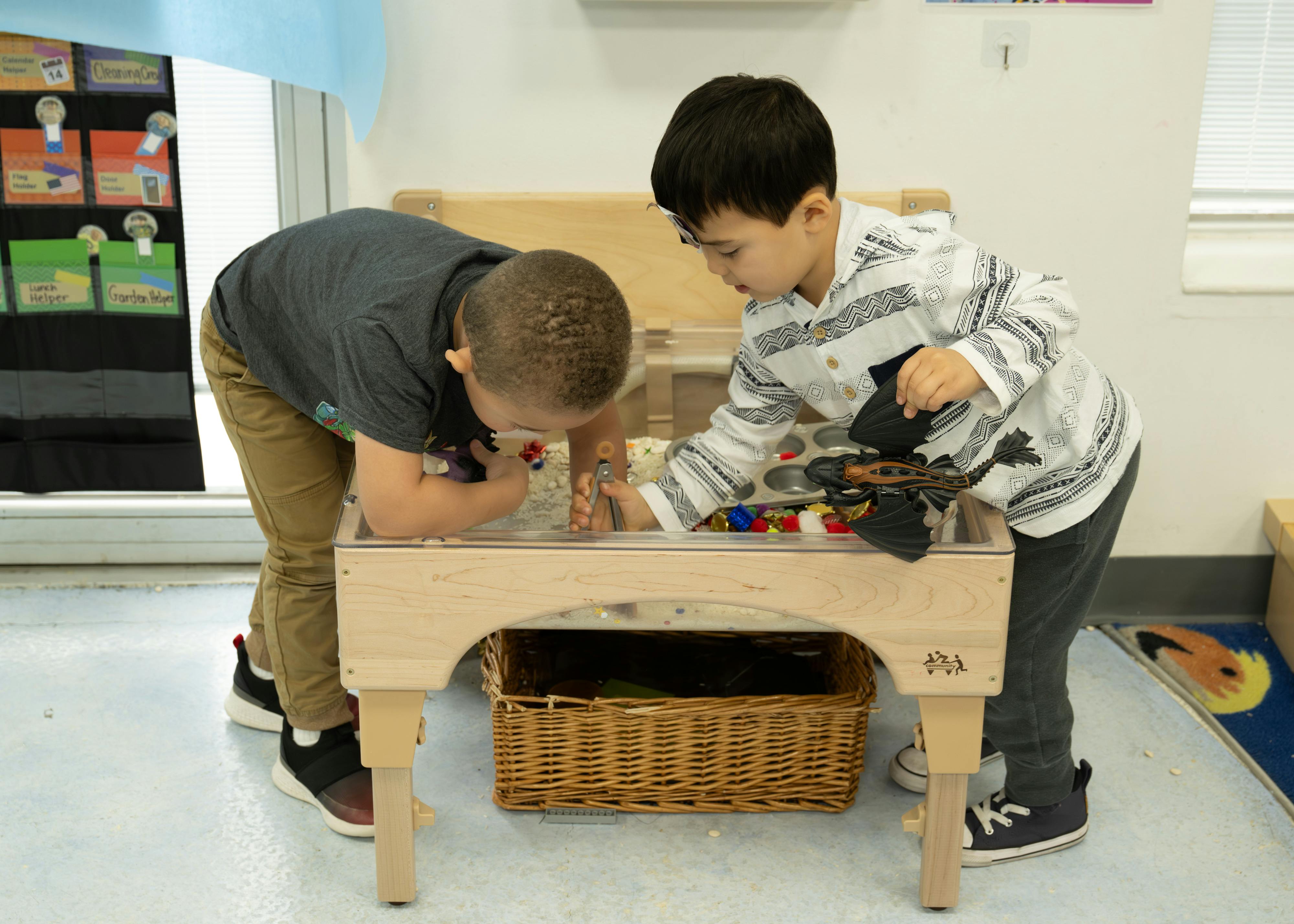 Two children playing with toys on a small table