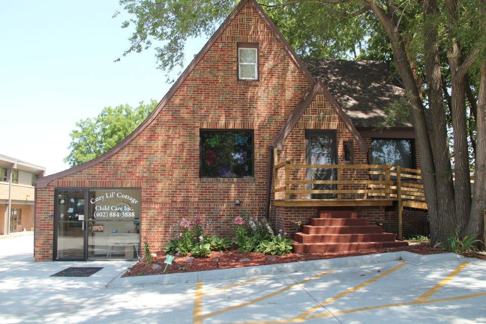 Brick building with a steep gabled roof and a wooden porch