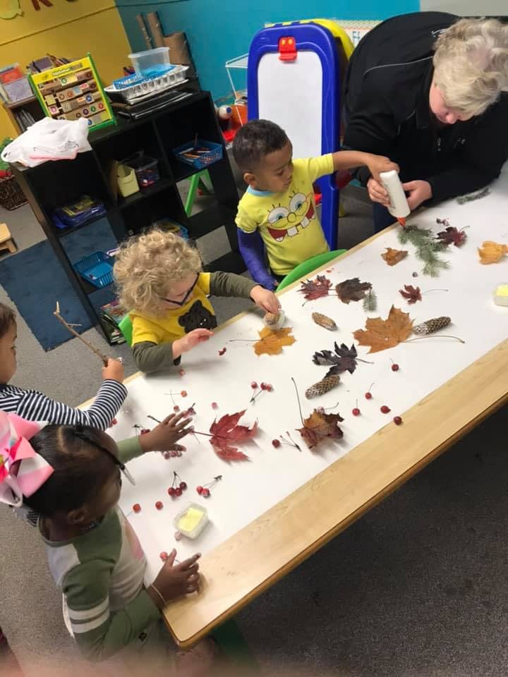 Adult and children doing an art activity with leaves