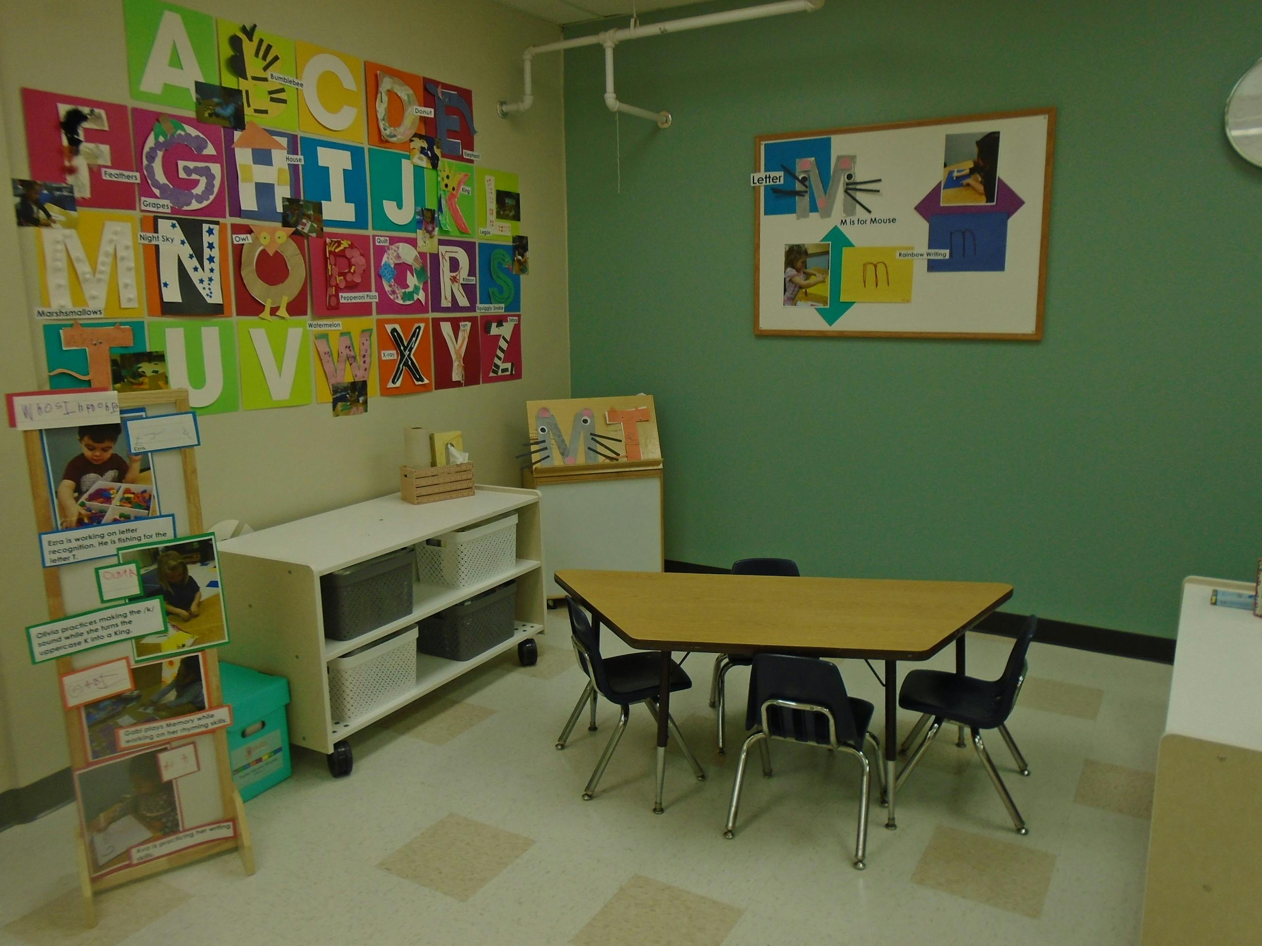 Classroom with an alphabet display, a learning table, and storage shelves