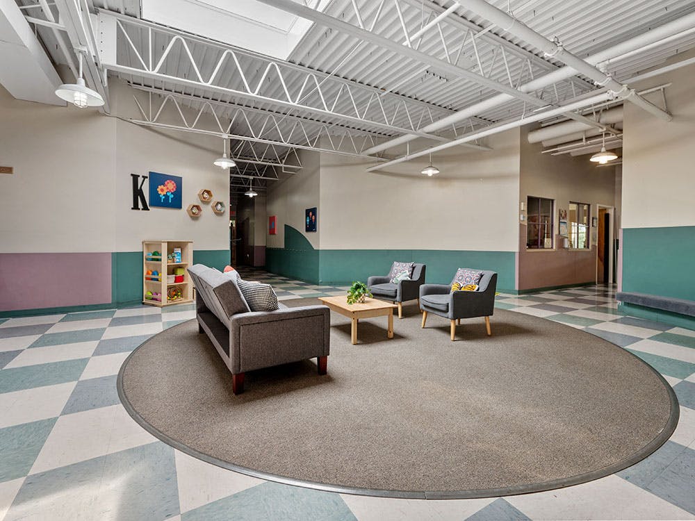Lounge area in a school with chairs and a couch on a round rug