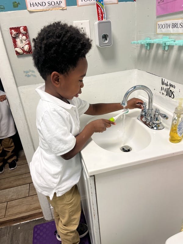 Child brushing teeth at a sink
