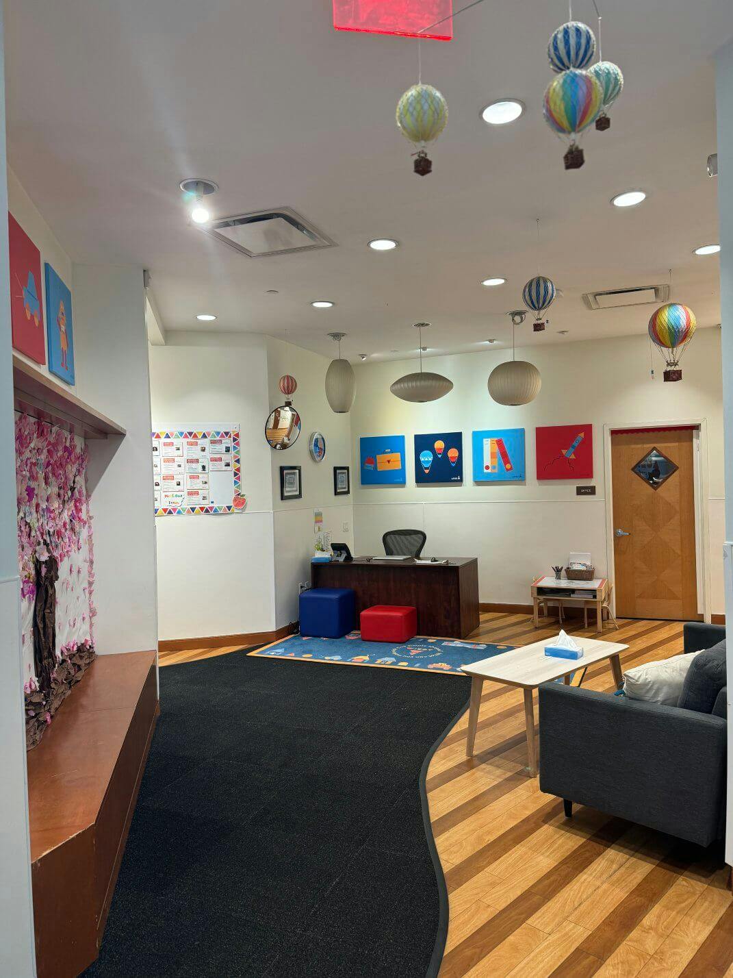 Reception area with hot air balloon decorations, a desk, and seating