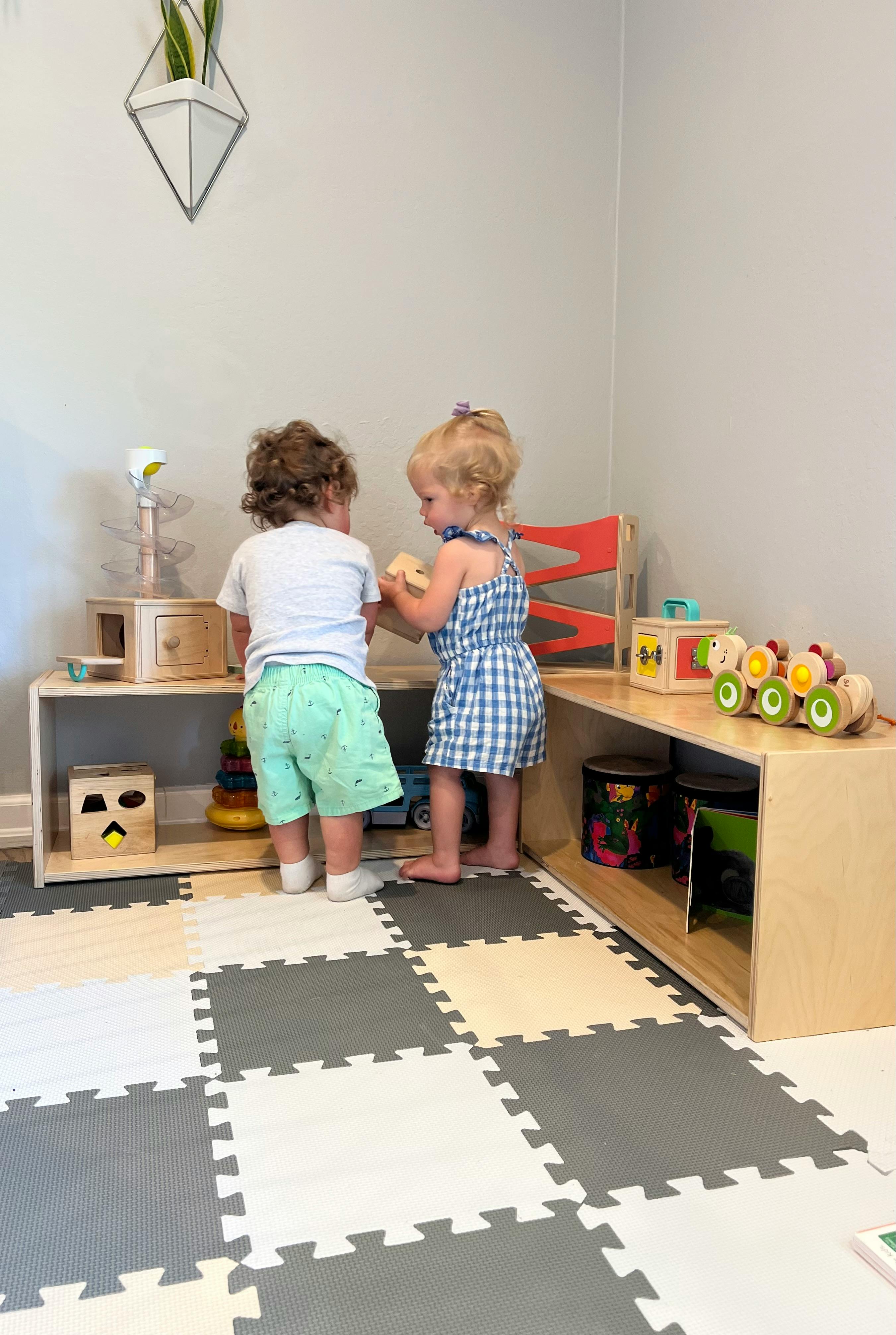 Two children playing with toys in a playroom