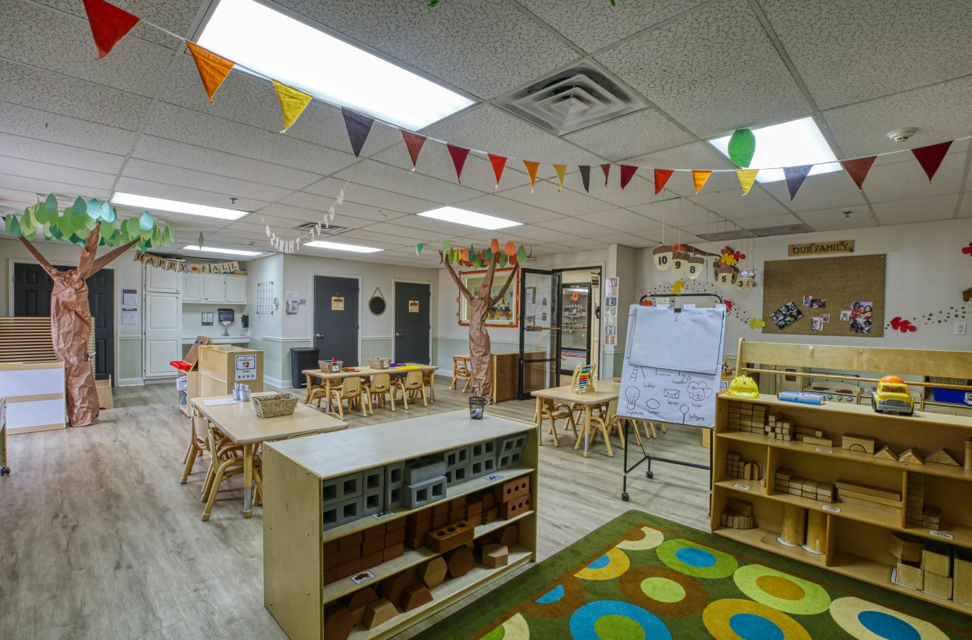 Empty colorful preschool classroom with small tables and chairs