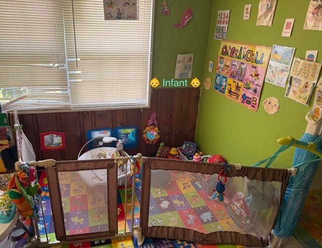 baby playpen in a room with a green wall