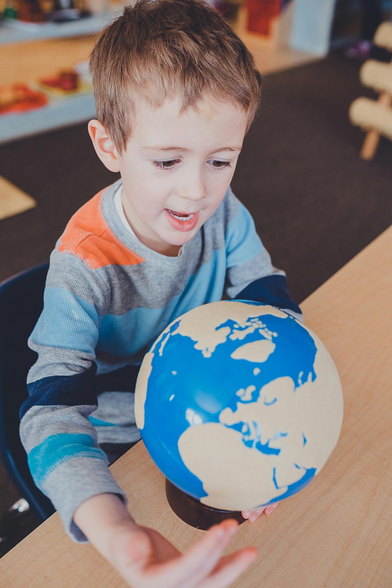 Child looking at a globe on a table