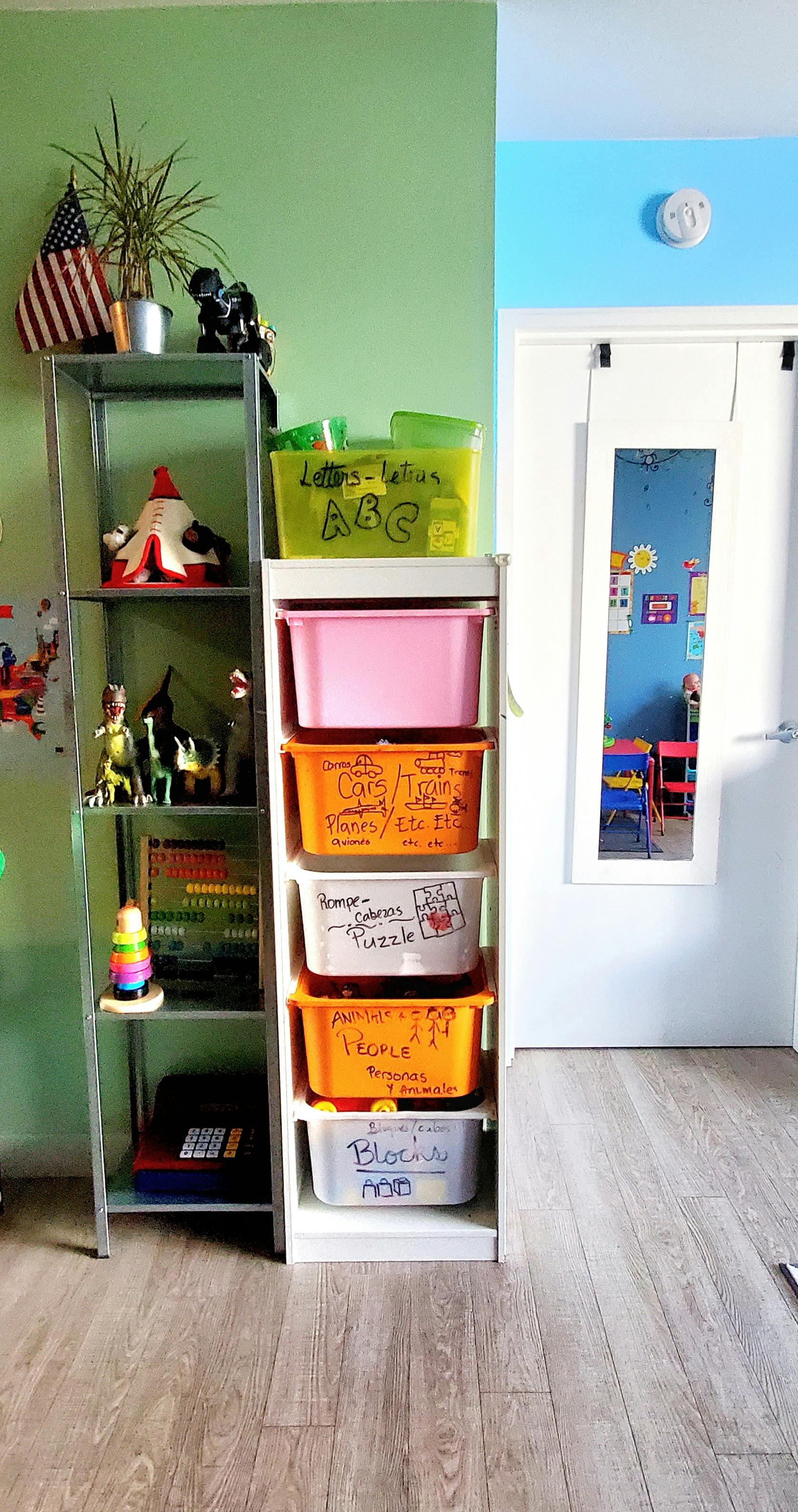Shelves with toys and storage bins in a room with green and blue walls