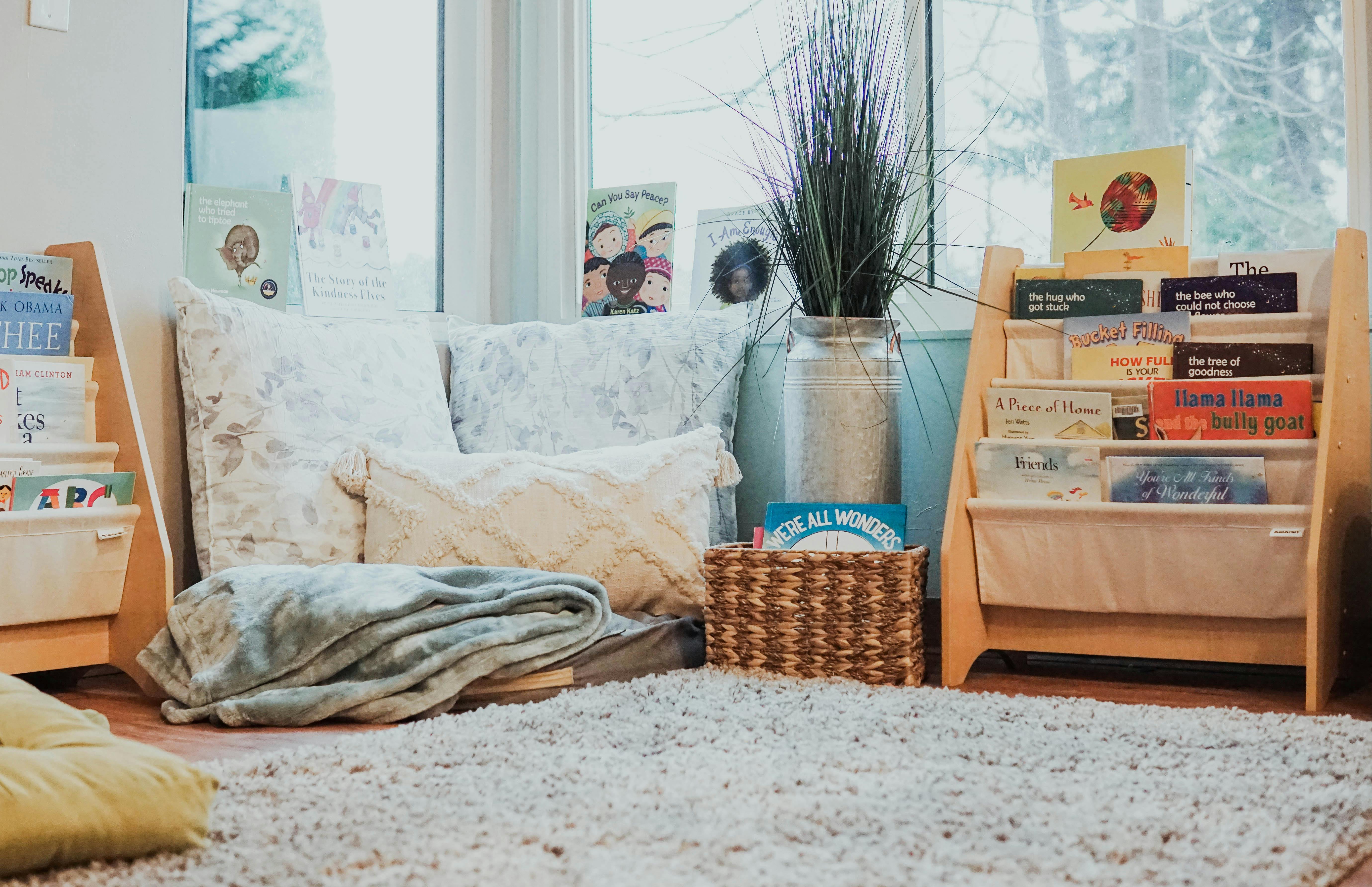 Cozy reading nook with pillows, blankets, and bookshelves