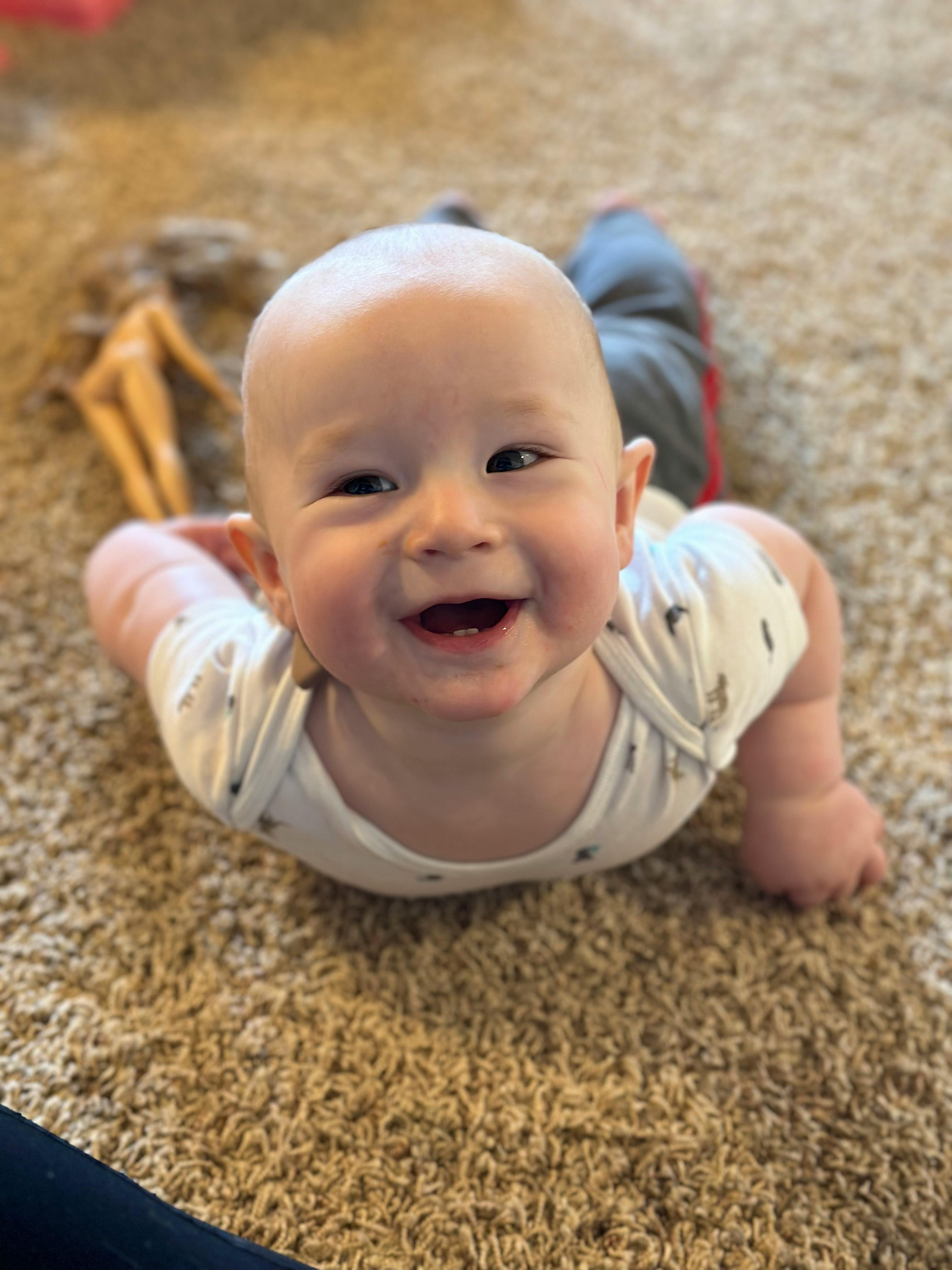 Child on stomach on carpet looking up
