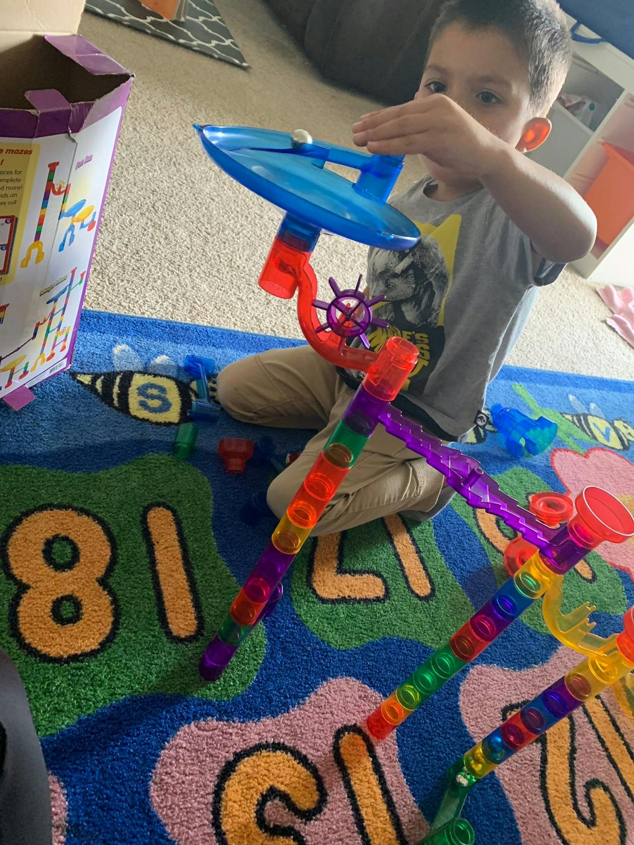 Child playing with a colorful marble run toy