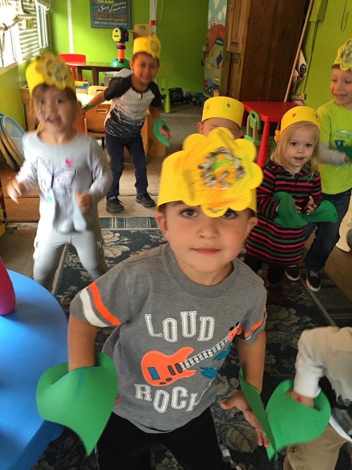 Children wearing yellow paper crowns and green paper cuffs