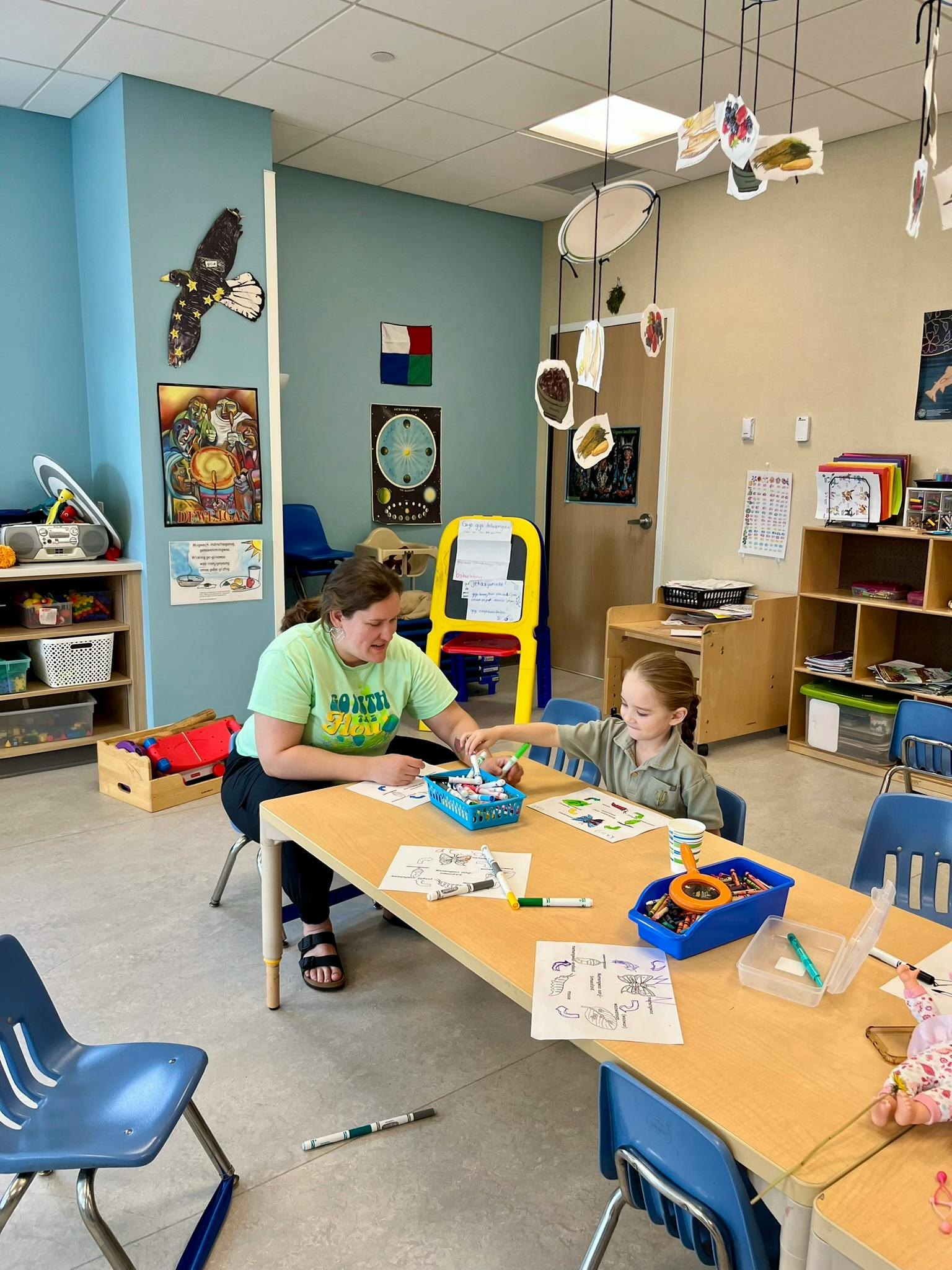 Adult and child at a table in a classroom