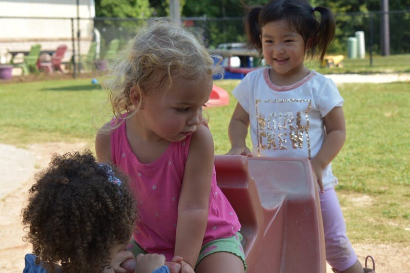 Three children playing on a small slide