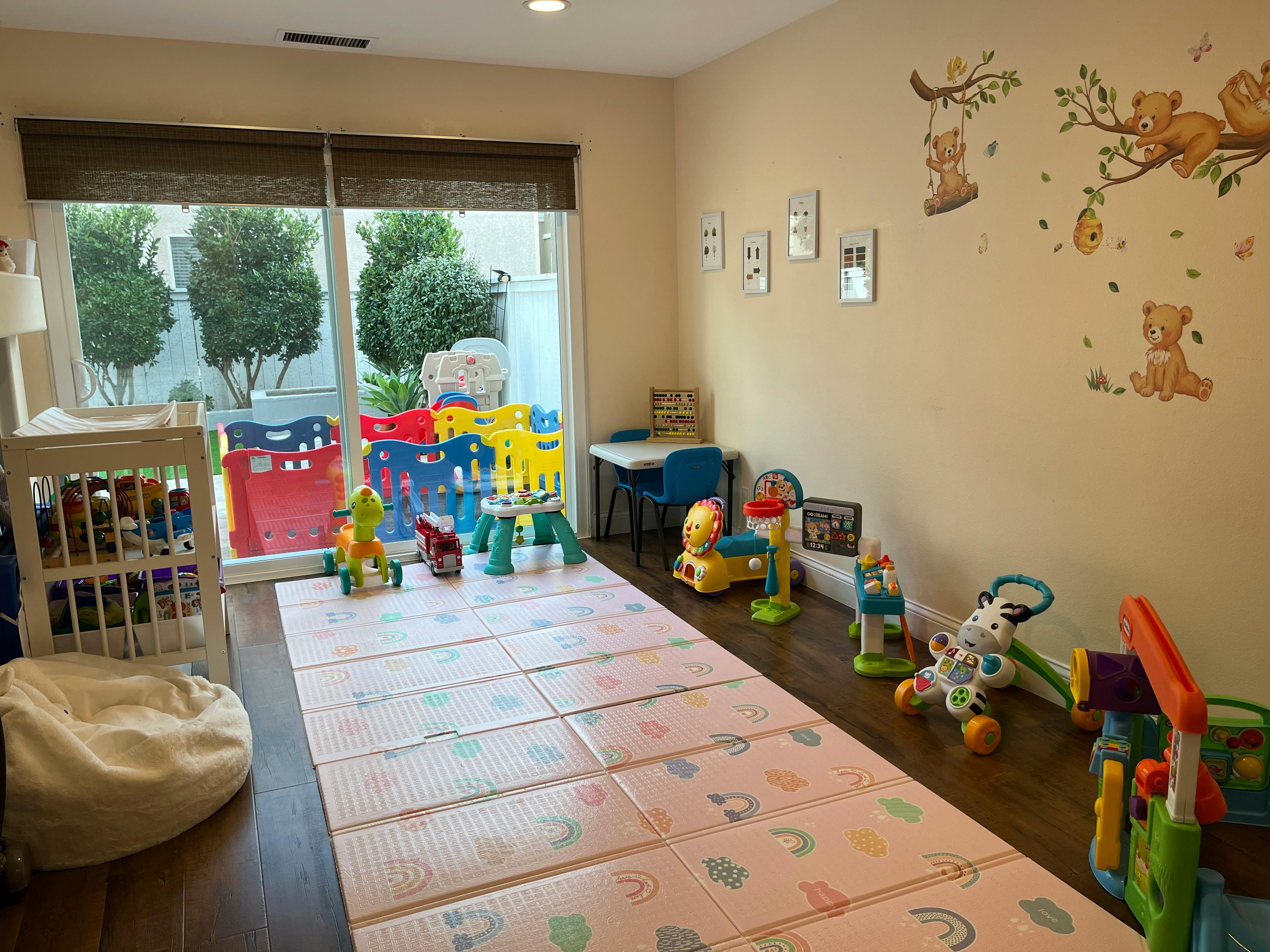 Playroom with a crib, playmat, and various toys