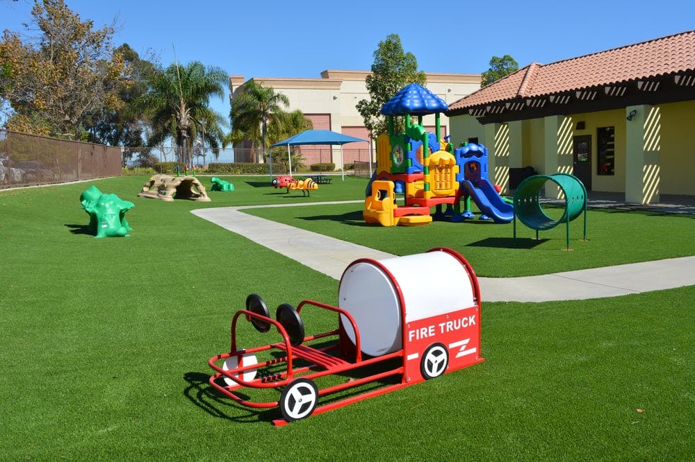 Playground with a red fire truck ride-on toy and colorful play structure