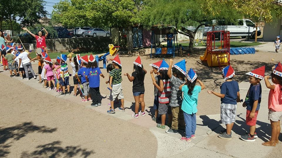 Children in Santa hats standing in a line outdoors