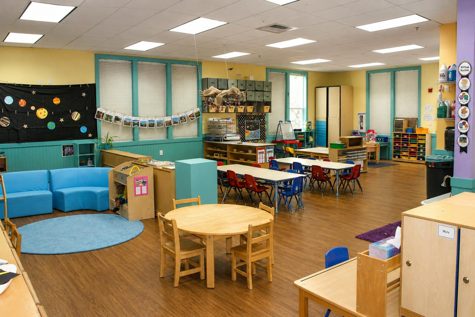 Empty preschool classroom with tables chairs and learning materials