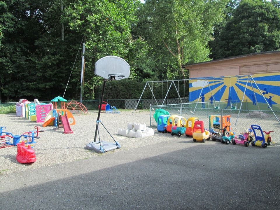 Outdoor playground with slides, swings, and ride-on toys