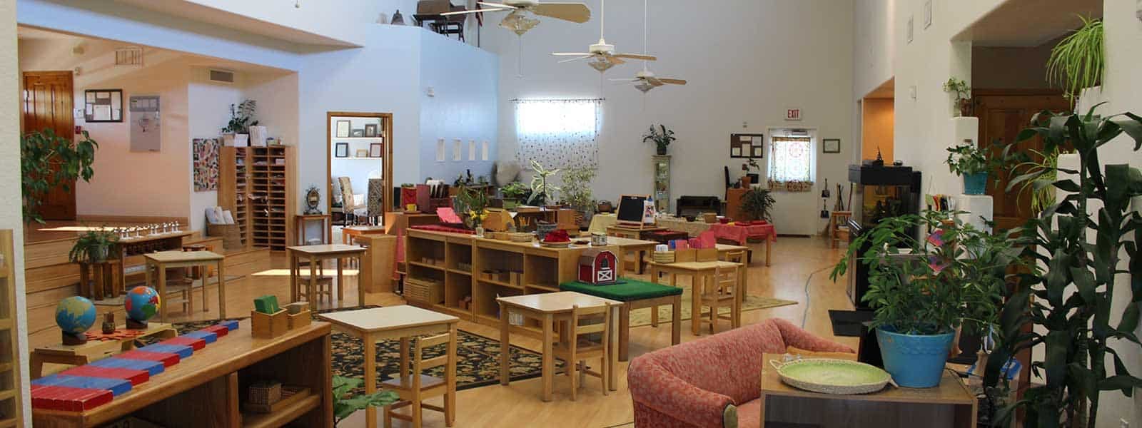 Classroom with wooden shelves, tables, and plants