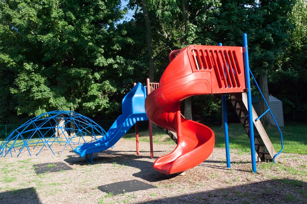Red spiral slide and blue slide with a blue climbing dome on a playground