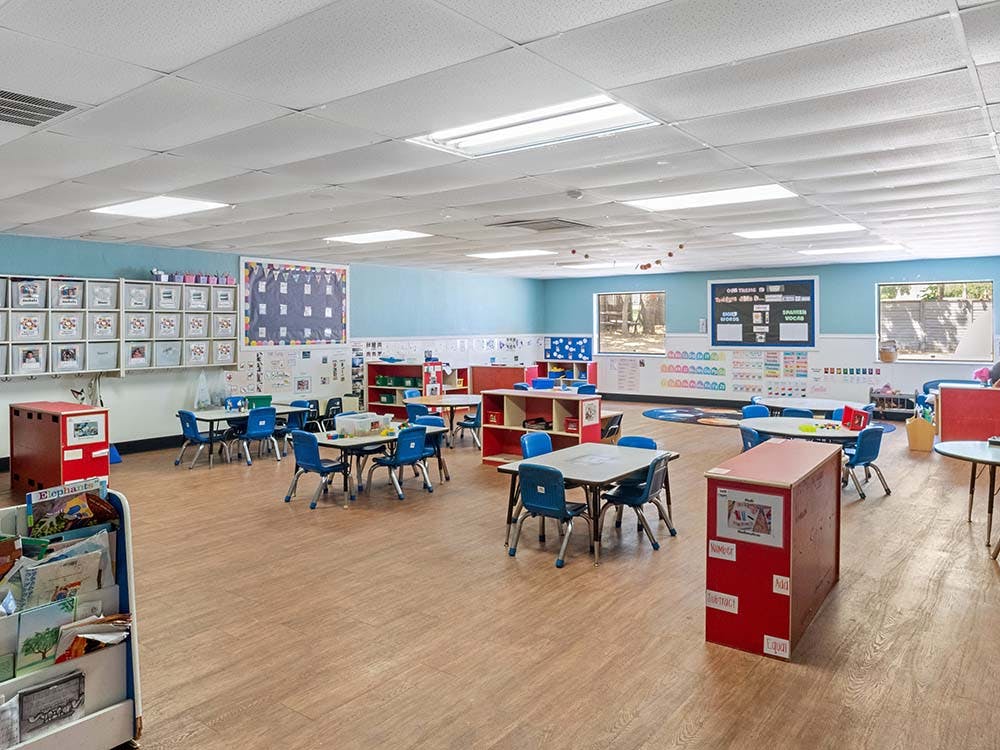 Empty colorful classroom with small tables and chairs