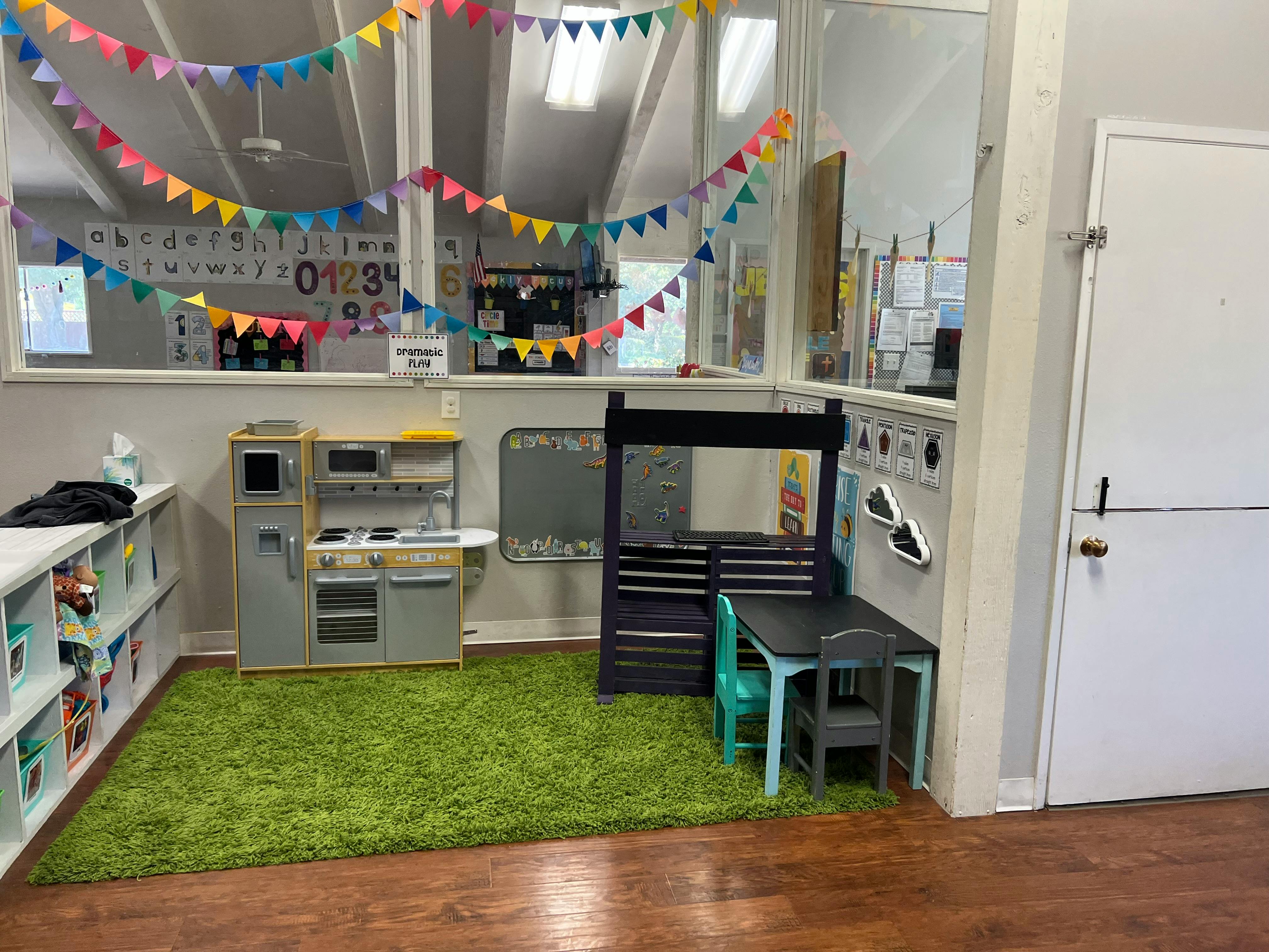 Playroom with toy kitchen, table, and colorful bunting