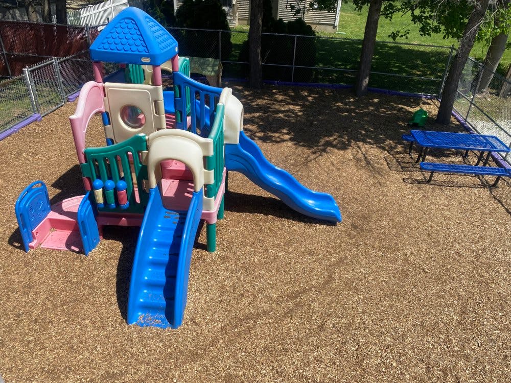 Playground with a small play structure and slides on wood chips