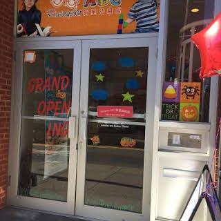 Glass doors with a "Grand Opening" sign and Halloween decorations