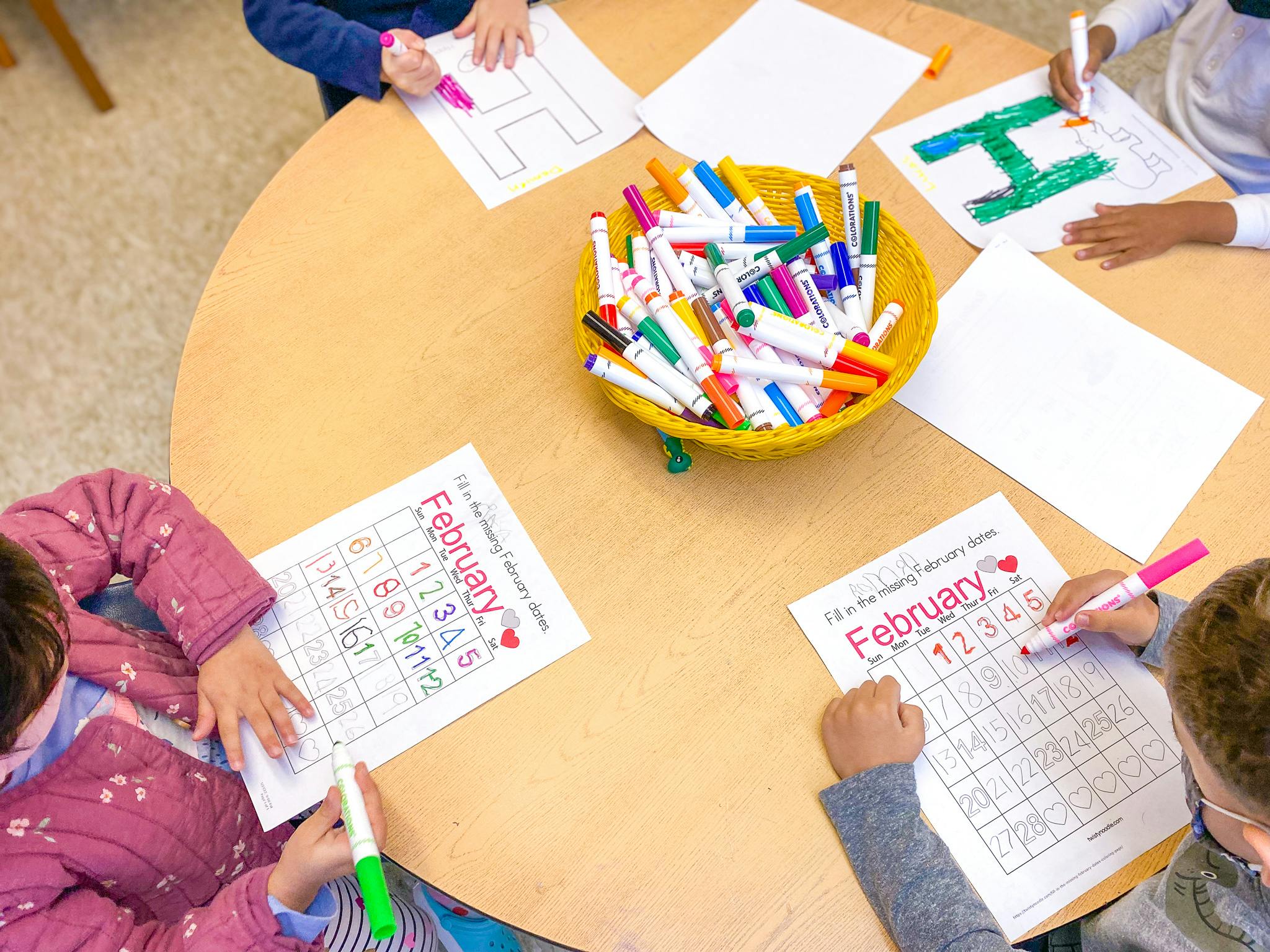Children drawing and writing at a table