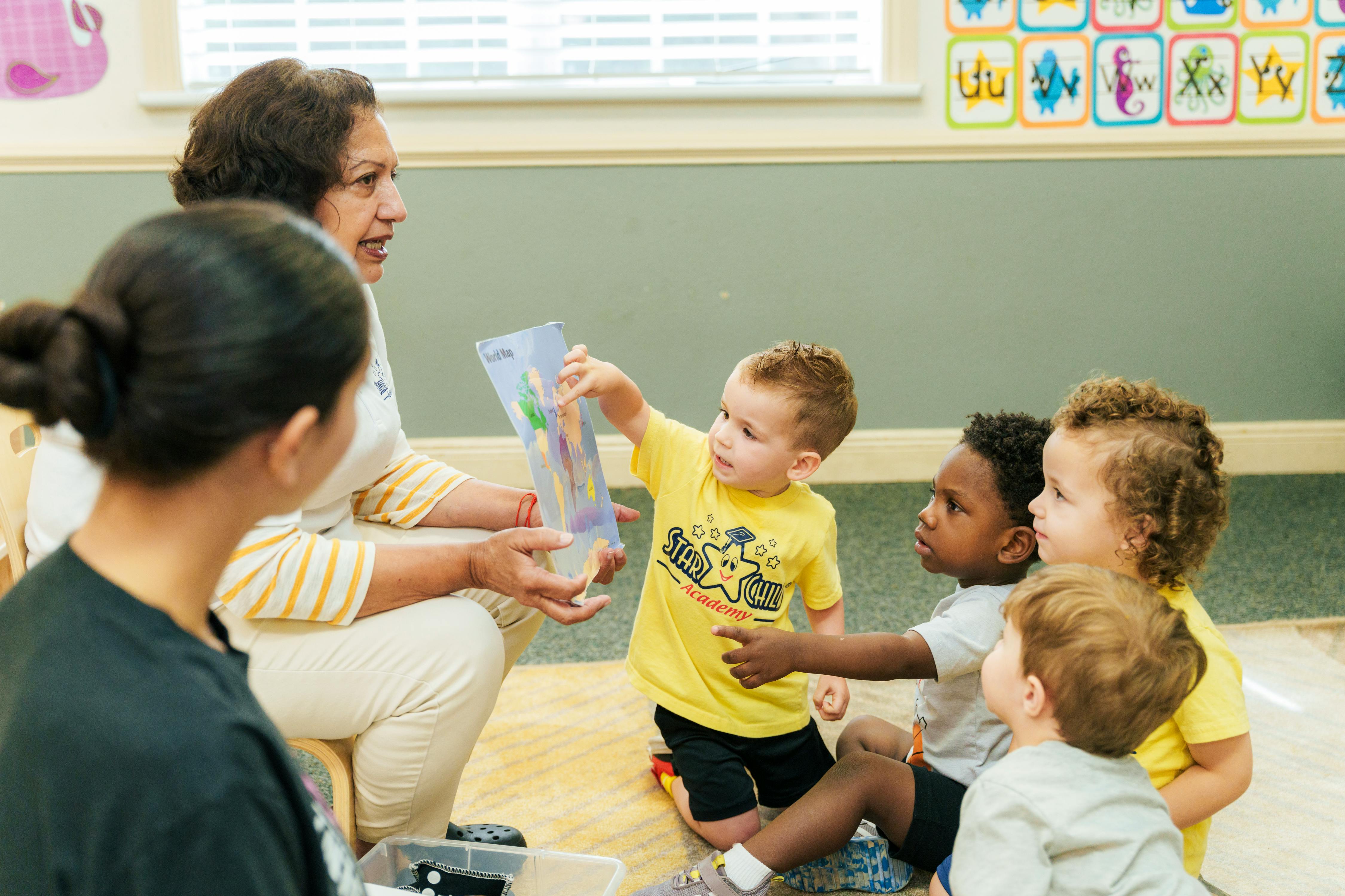 Adult showing a clear container to children in a classroom