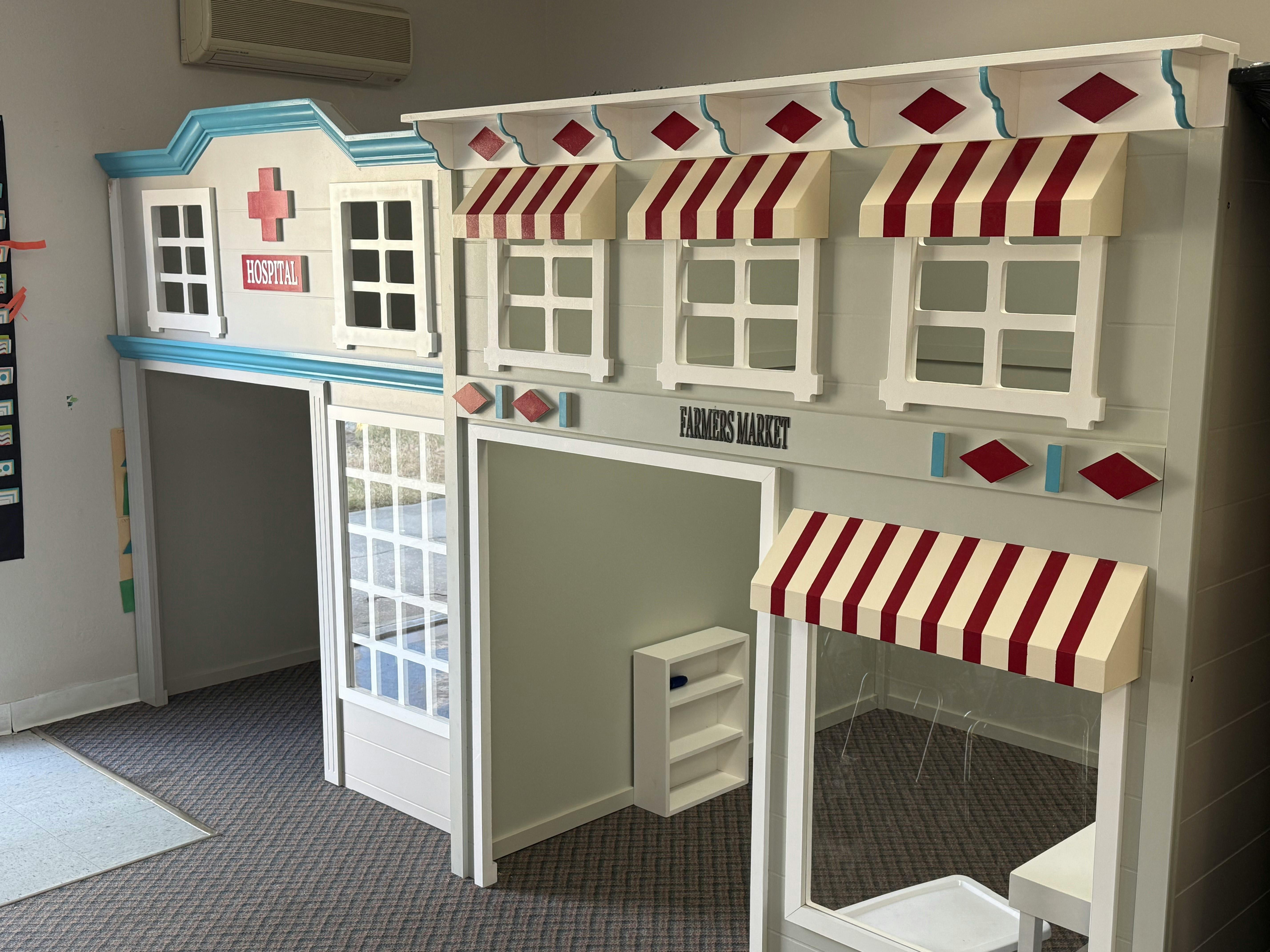 Playhouse structure featuring a hospital and farmers market theme