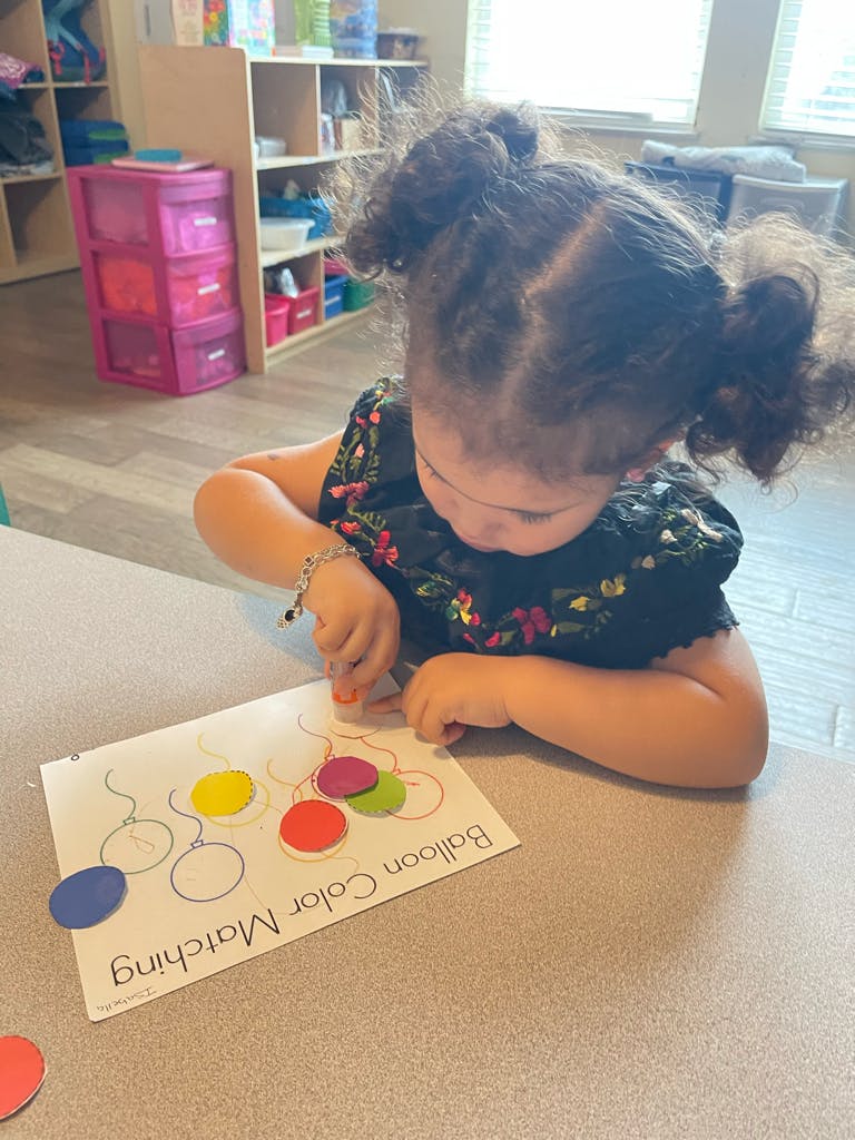 Child doing a balloon color matching activity