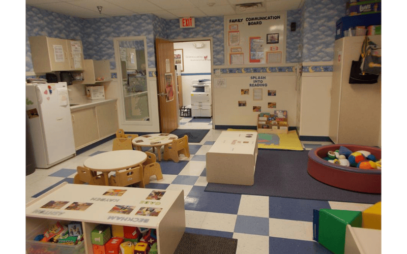 Classroom with small tables, chairs, and play areas