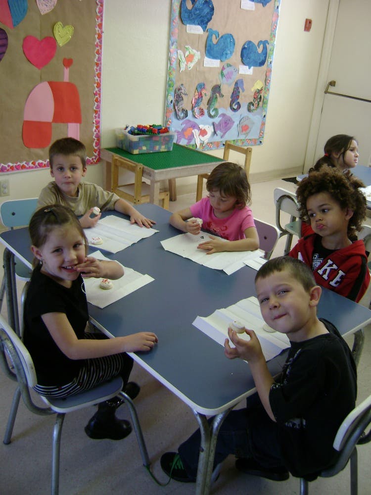 Children sitting at a table in a classroom