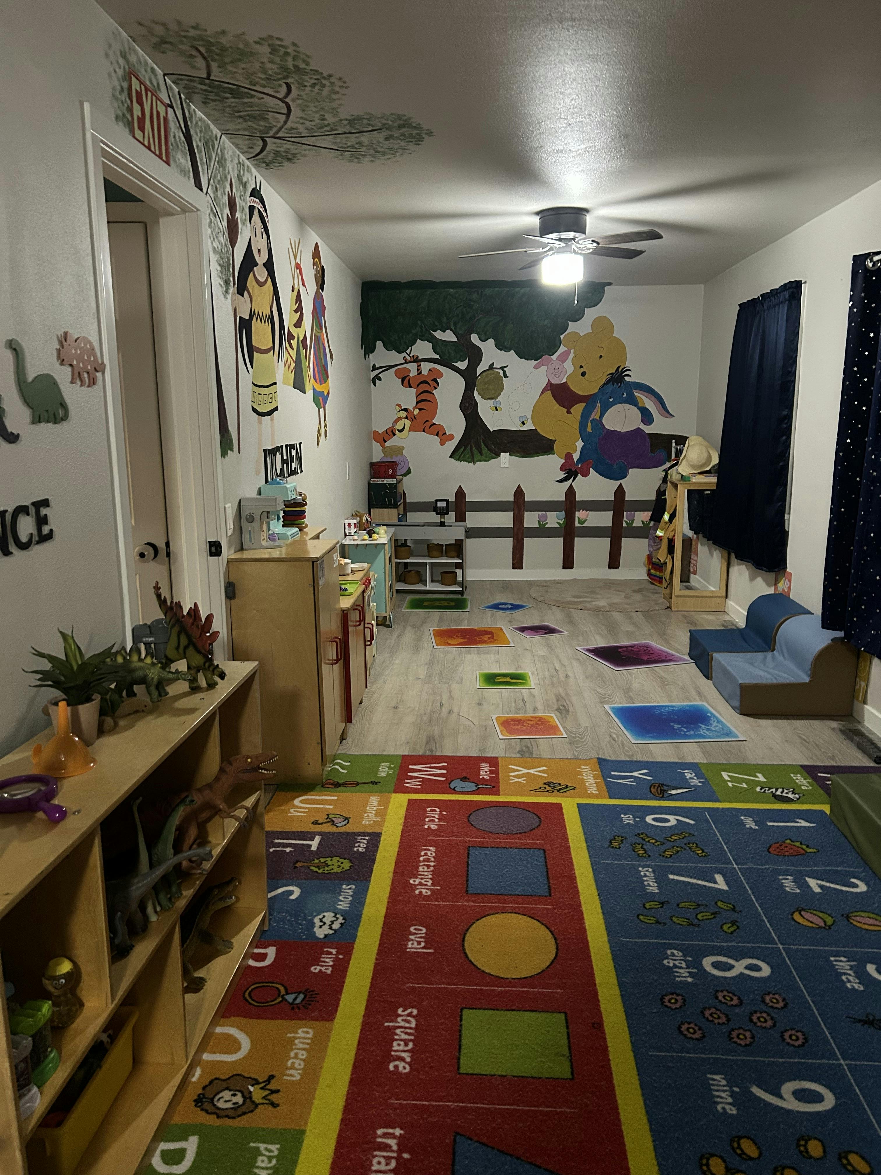 Playroom with colorful rugs, wall murals, and child-sized furniture